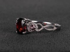 Welcome to my shop, you can find many beautiful gemstone jewelry here, and you also can ask for customized service. Main Stone: natural garnet, oval cut, measures 6X8mm, weigh about 1.72 carats.Accent Stones: pink tourmalineMetal: 925 sterling silver plated with rhodium. I also can provide metal options such as 14k solid yellow/white/rose goldSetting: prong settingMore rings : https://www.etsy.com/shop/XCjewelryStudio?ref=hdr_shop_menuIt's a perfect gift for the person who was born in January (B Wedding Ring Oval, Garnet Wedding Rings, Unique Wedding Rings, Garnet Wedding, January Birthstone Rings, Red Gemstones, January Birthstone, Wedding Rings Unique, Ring Oval