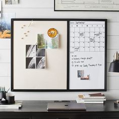 a desk with a calendar and pictures hanging on the wall