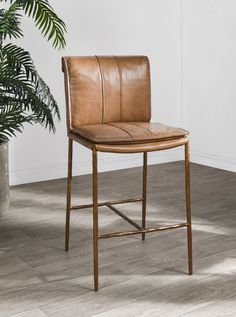 a brown leather chair next to a potted plant