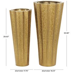 two tall gold vases sitting next to each other