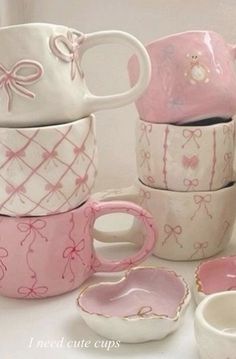 pink and white dishes with bows on them are stacked up in the shape of cups