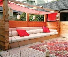 an outdoor living area with couches and rugs