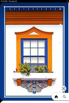 an orange and blue window with potted plants on the sill in front of it