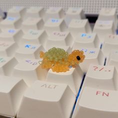 a small toy turtle sitting on top of a computer keyboard