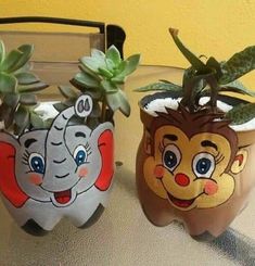 two potted plants with faces painted on them sitting on a table next to each other