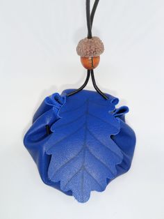 Medium Greek Blue Leather Oak Leaf Medicine Pouch, Celtic Tree Ogham, Lyrical Oak, Leather Pouch, Medicine Pouch, Pouch, Oak Leaf Medium handmade leather medicine pouch with wooden bead fastener for keeping crystals, trinkets, lucky charms and sentimental or magical items. The cord is long enough so you are able to adjust where it sits when around neck. Cord approx 100cm in length so when wearing the pouch the height of the pouch is roughly 45cm. The flap is an Oak leaf, which in the Celtic tree Blue Shoulder Bag With Zipper Pouch As Gift, Blue Shoulder Bag Mobile Phone Bag For Gift, Blue Shoulder Bag For Mobile Phone As Gift, Blue Zipper Coin Purse As Gift, Blue Bag With Zipper Pouch As Gift, Handmade Blue Coin Purse For Travel, Blue Coin Purse With Removable Pouch, Handmade Blue Travel Pouch, Blue Clutch Coin Purse For Gift