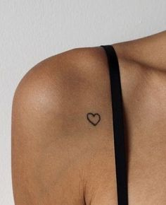 a woman with a heart tattoo on her shoulder