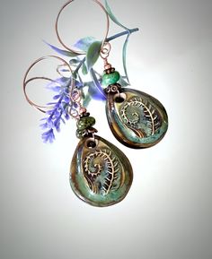 Celebrate the beauty of nature with these exquisite rustic woodland theme earrings. These earrings feature stunning ceramic Fern leaf charms, each measuring 30mm long by 25mm wide (1.18 x 0.98 inches). The Fern charms are intricately glazed on both sides with a captivating blend of opal, green, and brown hues, creating a mesmerizing effect reminiscent of a serene forest. Accentuating these charms are genuine 7.5mm Arizona Turquoise beads, renowned for their vivid blue-green color and natural beauty. Complementing the Turquoise beads are rich copper beads and spacer beads, adding a touch of earthy elegance. The earrings are completed with copper open hoop ear wires, providing a warm and rustic finish. With a total length of 2 3/4", these lightweight ceramic drop earrings are perfect for any Serene Forest, Earthy Elegance, Woodland Earrings, Botanical Earrings, Fern Leaf, Arizona Turquoise, Woodland Theme, Crafts Jewelry, Diy Crafts Jewelry