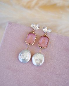 Add a touch of elegance and feminine flair to your wedding day look with our stunning Arabella Pink Drop Earrings. These beautiful gold and pink drop earrings feature eye-catching freshwater coin pearls, making them a perfect choice for the boho bride who wants a pop of color to her wedding look.Crafted with high-quality materials, these drop earrings are designed to last for years to come. The delicate design and modern glam appeal makes them perfect for brides who want to keep it simple yet el