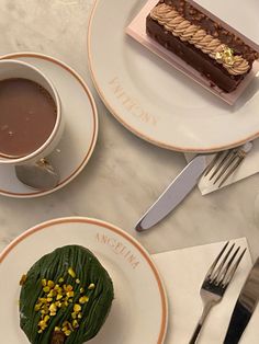 two plates with desserts on them sitting on a table next to utensils