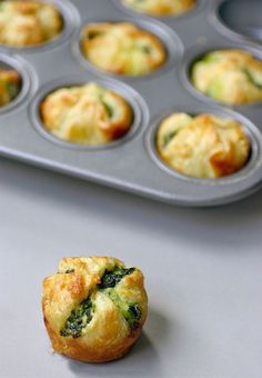 muffins with spinach and cheese in a muffin tin on a counter