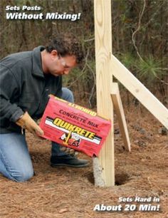 a man kneeling down next to a piece of wood