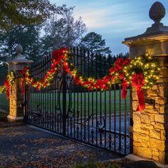 an iron gate decorated with christmas lights and decorations