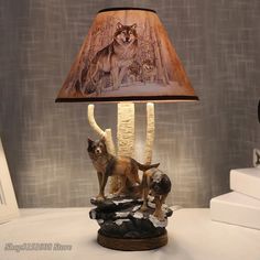 a lamp that is sitting on top of a table next to a dog and cat figurine