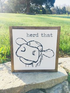 a sign that says, herd that on the side of a rock in front of some grass