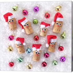 wine cork christmas ornaments with santa hats and glasses on them are displayed in a black frame