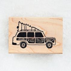 a rubber stamp with an image of a van and trees on the front, in black ink