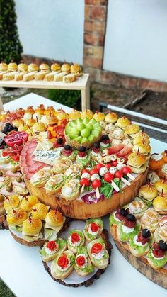 a table topped with lots of different types of food on top of wooden trays