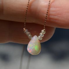 An Ethiopian Welo opal teardrop with an unusual khaki-tan base color sparkles with rainbow fire and is nestled between tiny microfacted mystic quartz beads, all knotted on tan colored silk that disappears on the skin.   Scroll  through the photos to see how the fire changes with the light. All of my opals are genuine earth-mined and are not created in a lab.   18 inches Sterling silver clasp Silk Necklace, Mystic Quartz, Rainbow Gemstones, Rainbow Fire, Gem Necklace, Tourmaline Stone, Quartz Beads, Rough Opal, Strawberry Quartz