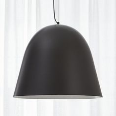 a black lamp hanging from a ceiling next to a window with white curtains in the background