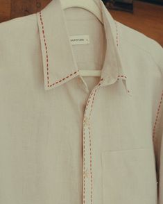 a white shirt with red stitching on it