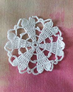 white crocheted doily on pink fabric