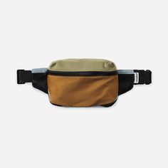 a brown and black fanny bag sitting on top of a white wall