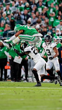 a football player jumping in the air with his foot on another player's shoulder