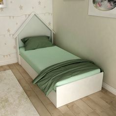 a small bed with green sheets in a white walled room next to a painting on the wall