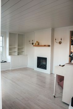 an empty living room with white walls and wood floors