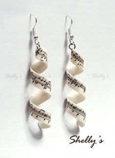 two white earrings with musical notes hanging from them