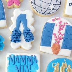 decorated cookies are arranged on a table with the words mamma mia written in blue