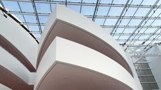 the interior of a modern building with glass ceiling and skylight above it, as well as an artistic sculpture