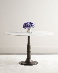 a white marble table with purple flowers on top