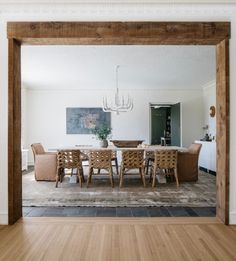 a dining room table with chairs and a chandelier hanging from the ceiling above it