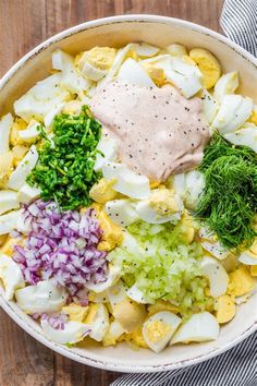 a large bowl filled with different types of vegetables and sauces on top of it