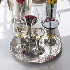 three glasses of wine on a silver tray