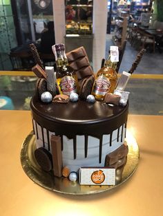 a chocolate cake decorated with liquor bottles and candies