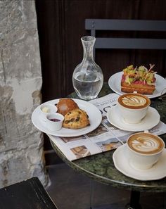 two cups of coffee and pastries on a table