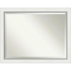 a white framed mirror on a wall