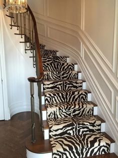 a set of stairs with zebra rugs and chandelier on each handrail