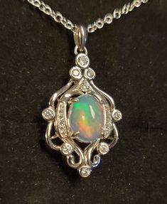 "Gorgeous Natural Rainbow Ethiopian Opal 8x10mm with Full Rainbow  Fire! The Opal In The Photos And Video Is An Example Of Available Stones Color And Quality Stones Vary. You Can Ask To See Stones. Be Sure To See Video! 925 Sterling Silver Rococo Chandelier Necklace With 9+ CZ Accents Giving Sparkle. 20\"  Sterling Silver Chain. Several Chain Length Options Ask Seller About Availability. Great Gift! Gift Box Included" Sterling Silver Oval Cabochon Multi-stone Jewelry, Sterling Silver Multi-stone Jewelry With Oval Cabochon, Silver Necklace With Bail In Fine Jewelry Style, Silver Oval Multi-stone Necklaces, Oval Silver Multi-stone Necklaces, Silver Oval Necklace With Bail, Rococo Chandelier, Chandelier Necklace, Full Rainbow