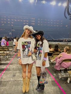 two women standing next to each other in front of an arena