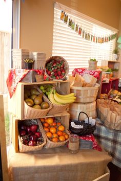 several wooden boxes filled with different types of fruits and vegetables in front of a window