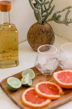 grapefruit, lime and orange slices on a cutting board next to a bottle of olive oil