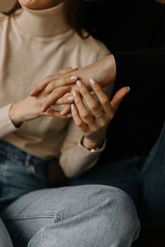 two people sitting on the floor holding their hands in each other's palms,