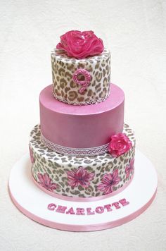 a three tiered cake with leopard print and pink flowers