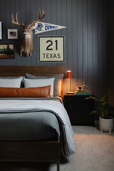 a bed room with a neatly made bed and a deer head mounted on the wall