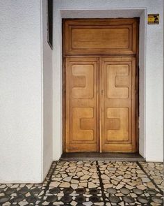 an entrance with two wooden doors and tiled floor