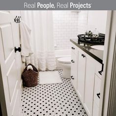 a white bathroom with black and white floor tiles